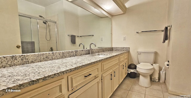 bathroom with toilet, vanity, a shower with door, and tile patterned flooring