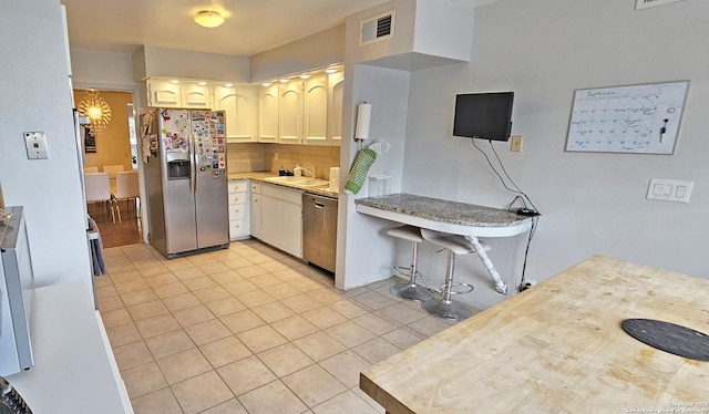 kitchen with stainless steel appliances, sink, and light tile patterned floors