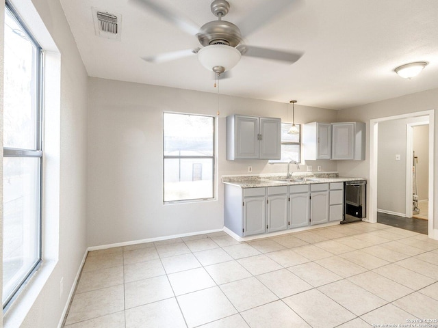 kitchen featuring sink, gray cabinetry, light tile patterned floors, black dishwasher, and ceiling fan