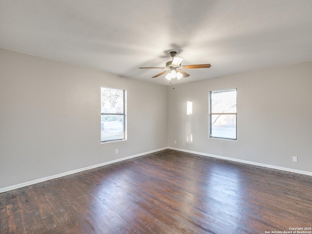 empty room with dark wood-type flooring and ceiling fan