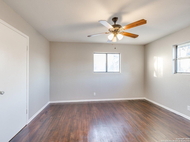 empty room with dark wood-type flooring and ceiling fan