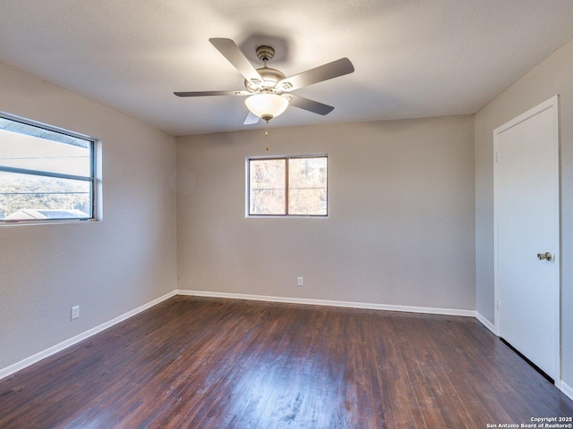 spare room featuring plenty of natural light, dark hardwood / wood-style floors, and ceiling fan