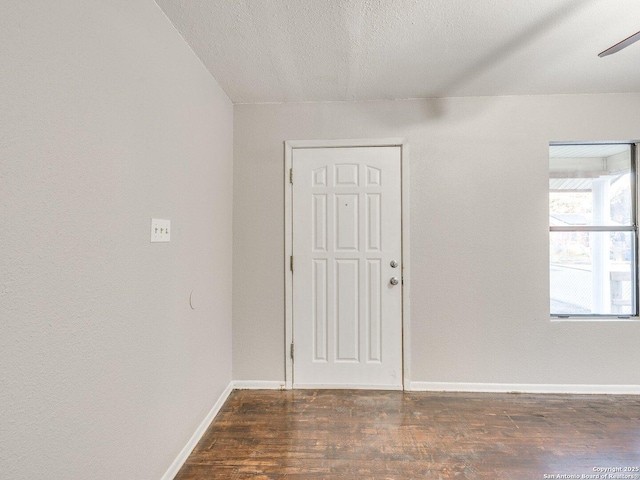 foyer entrance with dark wood-type flooring and a textured ceiling