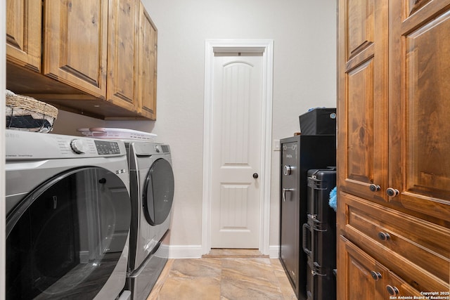 washroom with washer and clothes dryer and cabinets