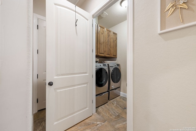 washroom with cabinets and washing machine and dryer