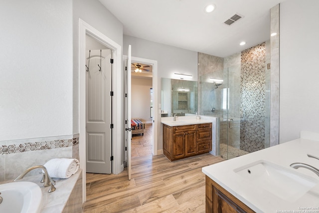 bathroom with vanity, plus walk in shower, and wood-type flooring