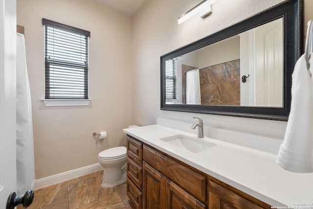 bathroom featuring walk in shower, vanity, and toilet