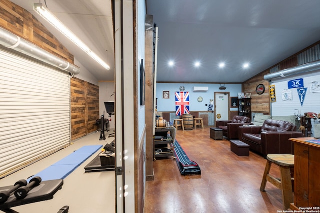 interior space with lofted ceiling, wooden walls, and a wall unit AC