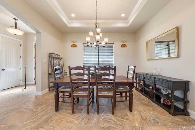 dining space featuring crown molding, a notable chandelier, and a tray ceiling