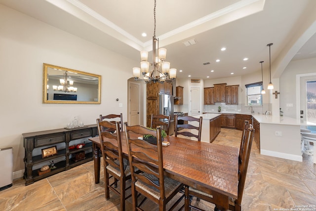 dining area featuring a raised ceiling, ornamental molding, and an inviting chandelier