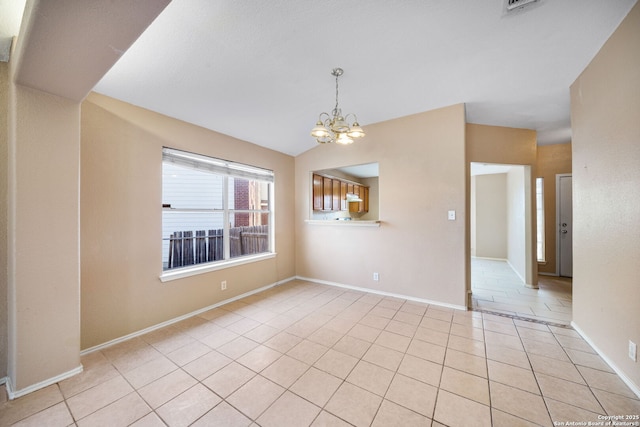 empty room featuring light tile patterned flooring, lofted ceiling, and an inviting chandelier