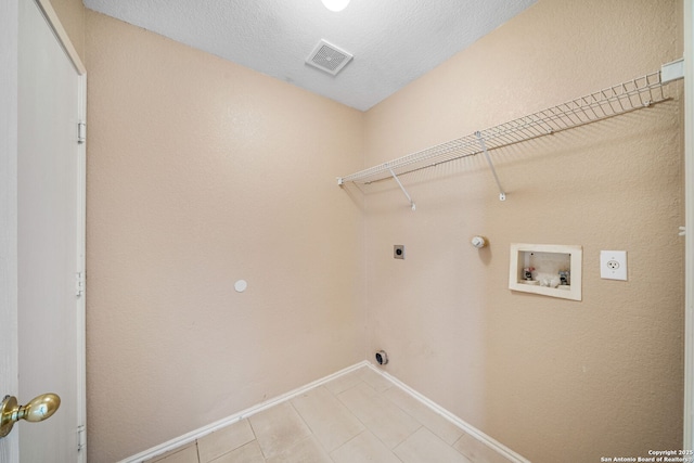 laundry room featuring gas dryer hookup, hookup for a washing machine, a textured ceiling, and electric dryer hookup