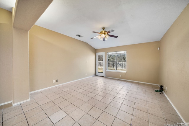 empty room featuring lofted ceiling, ceiling fan, and light tile patterned flooring