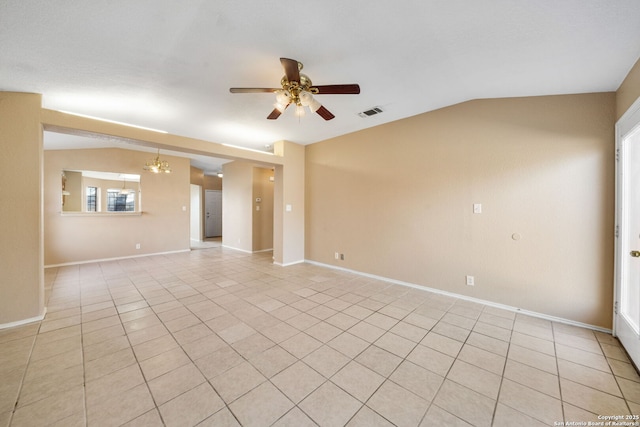 tiled empty room featuring lofted ceiling and ceiling fan with notable chandelier