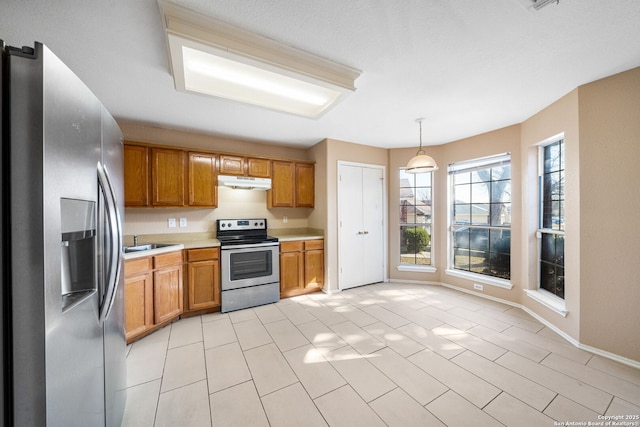 kitchen with stainless steel appliances, hanging light fixtures, and sink