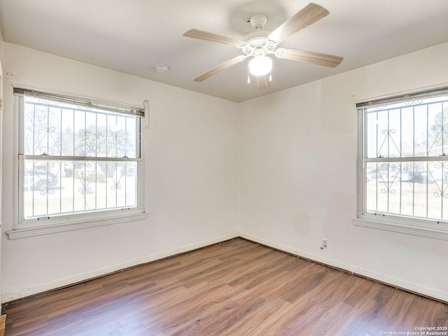 empty room with hardwood / wood-style flooring and ceiling fan