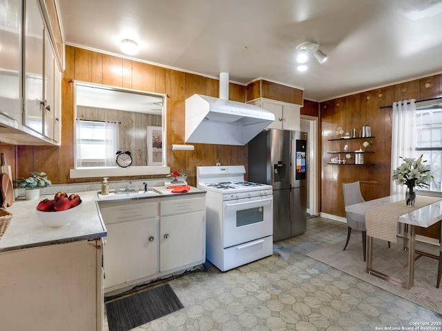 kitchen featuring white cabinetry, white gas range, wooden walls, and extractor fan