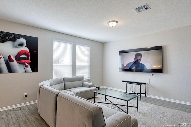 living room featuring hardwood / wood-style flooring and a textured ceiling