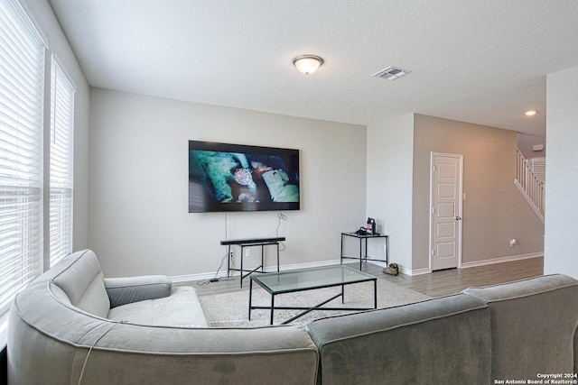 living room with light hardwood / wood-style floors and a textured ceiling