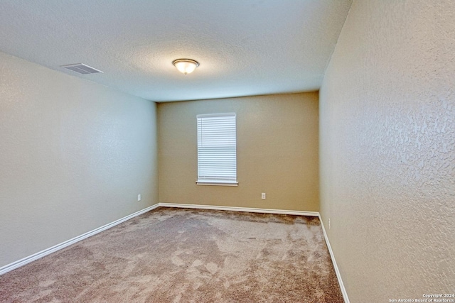 carpeted spare room with a textured ceiling