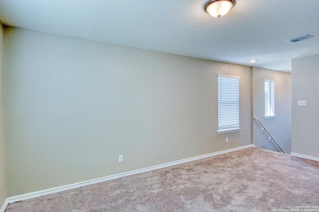 carpeted spare room featuring a textured ceiling