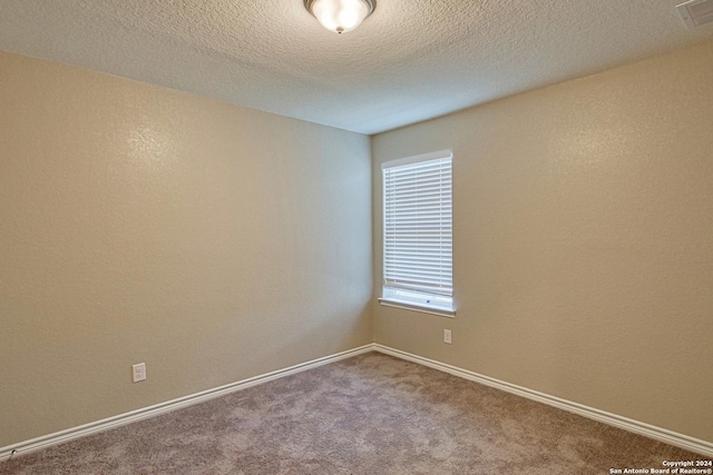 unfurnished room with carpet floors and a textured ceiling