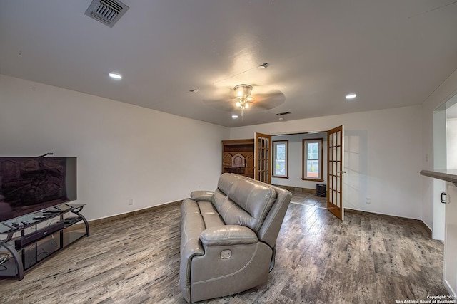 living room featuring wood-type flooring, french doors, and ceiling fan