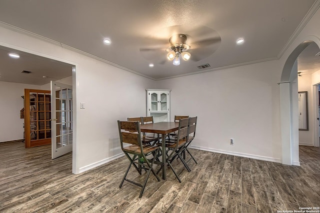 dining area featuring crown molding, ceiling fan, dark hardwood / wood-style floors, and french doors