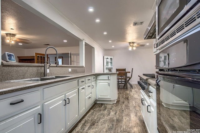 kitchen with sink, white cabinetry, ornamental molding, dark hardwood / wood-style flooring, and ceiling fan