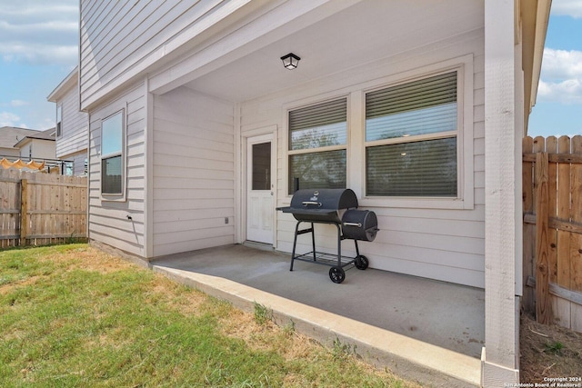 view of exterior entry with a yard and a patio