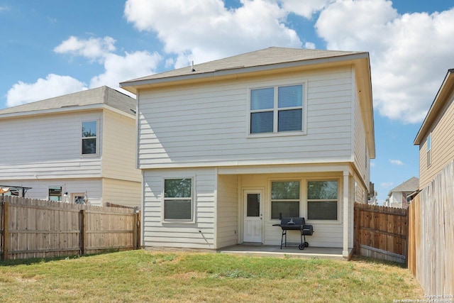 rear view of property featuring a yard and a patio