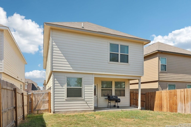 rear view of property featuring a yard and a patio area