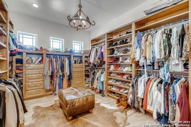 walk in closet featuring a notable chandelier