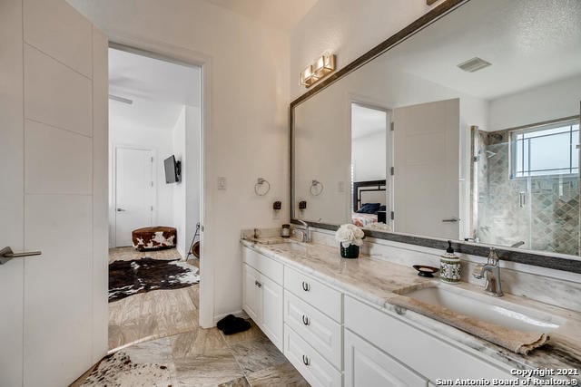 bathroom featuring vanity and a shower with shower door