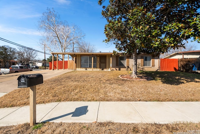 ranch-style home featuring a carport and a front lawn