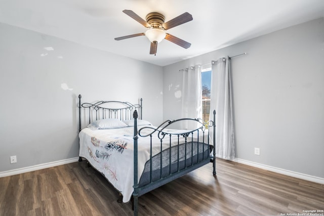 bedroom with dark hardwood / wood-style flooring and ceiling fan