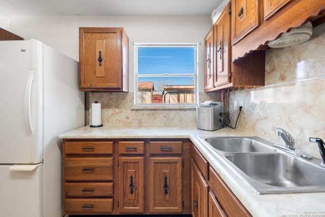 kitchen featuring white refrigerator, sink, and backsplash