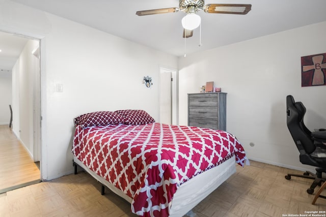 bedroom with ceiling fan and parquet flooring