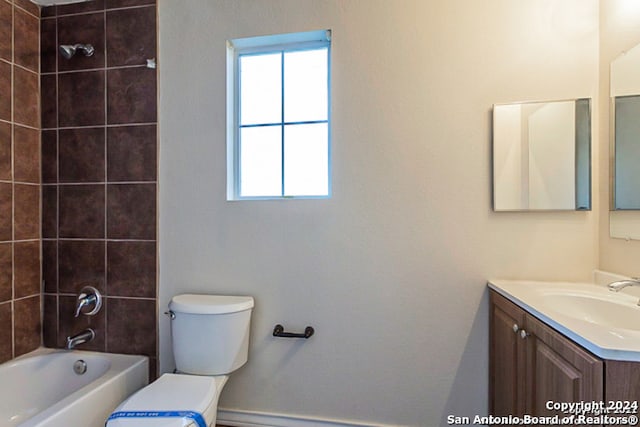 full bathroom with vanity, tiled shower / bath combo, and toilet