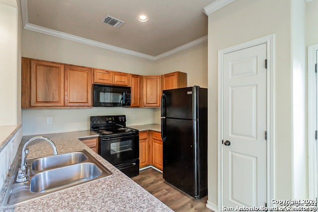 kitchen with sink, ornamental molding, black appliances, and dark hardwood / wood-style floors