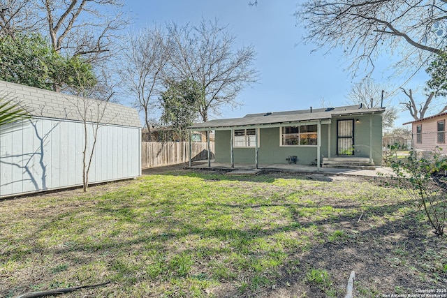 back of house with a yard and a patio