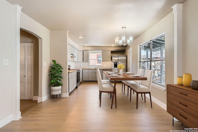 dining area with light hardwood / wood-style floors and a chandelier