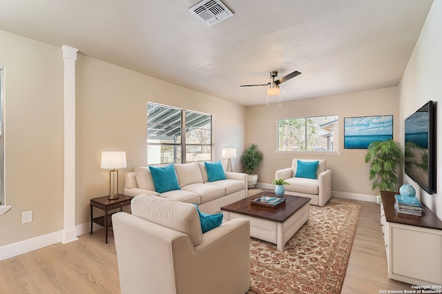 living room featuring light hardwood / wood-style flooring, a wealth of natural light, and ceiling fan