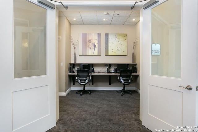 carpeted office space featuring built in desk and a paneled ceiling