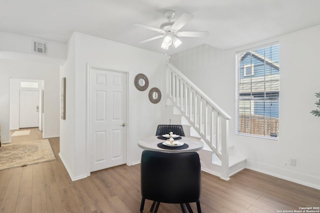 staircase with wood-type flooring and ceiling fan