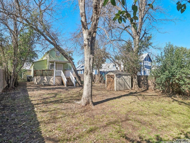 view of yard with a wooden deck and a storage unit