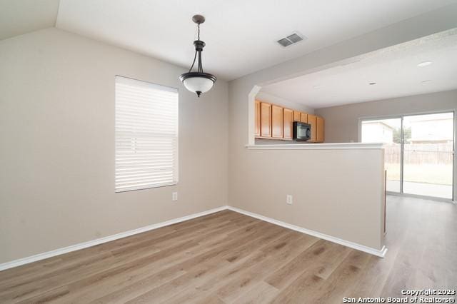 unfurnished dining area featuring light wood-type flooring