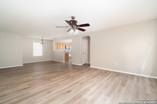 unfurnished living room featuring ceiling fan and hardwood / wood-style floors