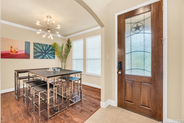 dining room featuring hardwood / wood-style flooring, ornamental molding, and a chandelier