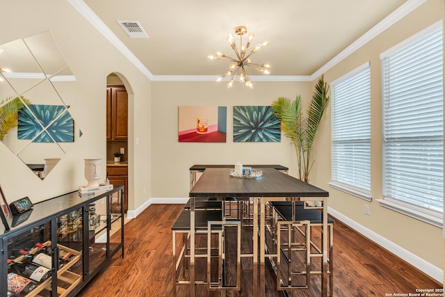 dining area featuring an inviting chandelier, crown molding, and dark hardwood / wood-style floors